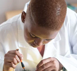 Black electronics technician testing a circuit board