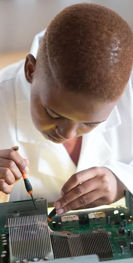 Black electronics technician testing a circuit board