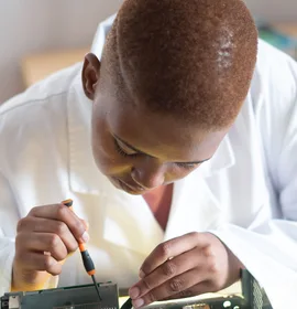 Black electronics technician testing a circuit board