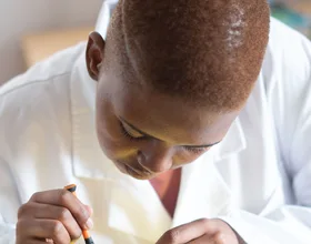 Black electronics technician testing a circuit board