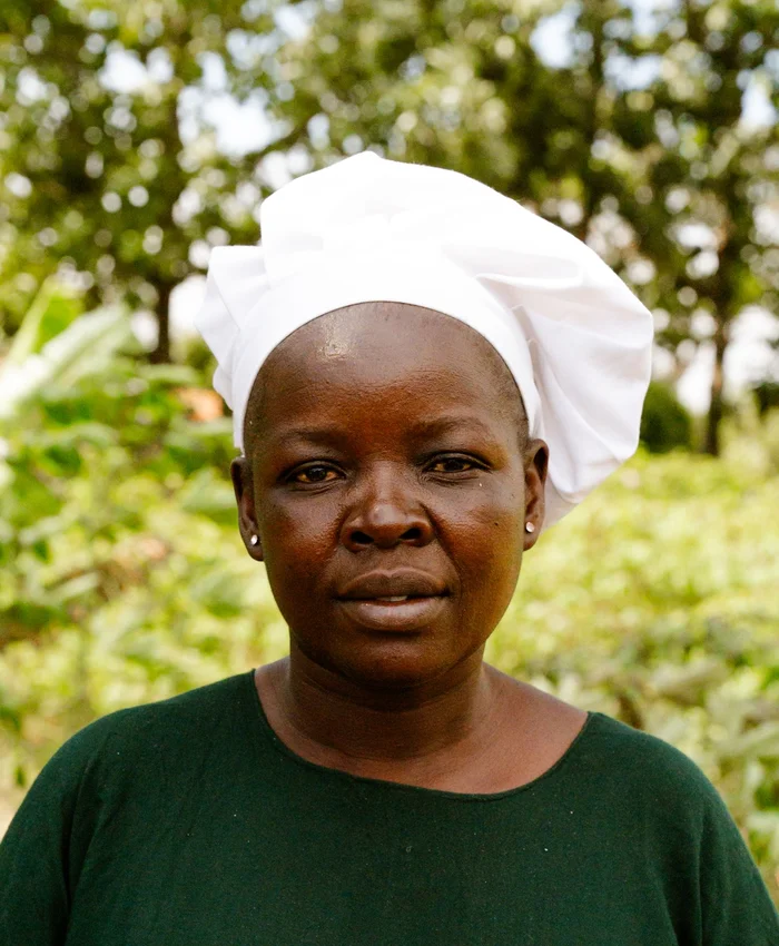 Black woman chef outdoors in a white chef hat