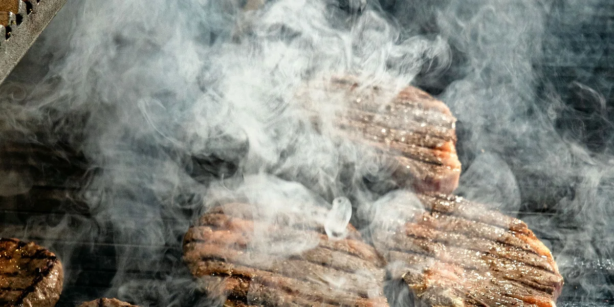 Steaks and burgers cooking on a grill