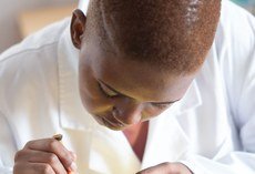 Black electronics technician testing a circuit board