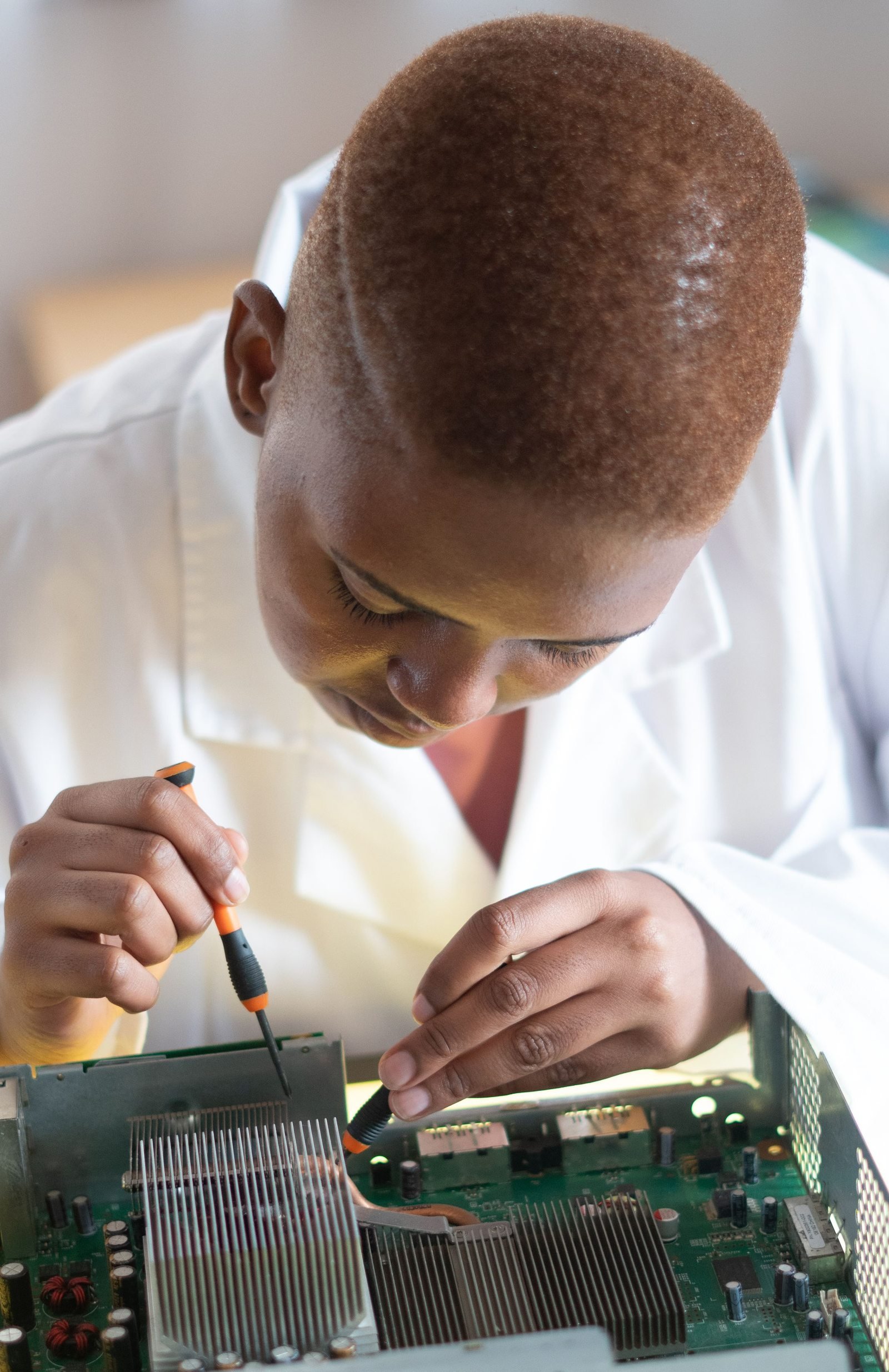 Black electronics technician testing a circuit board