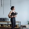Black woman holding a yoga mat in a studio