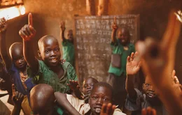 Pupils raising their hands in a Kitgum classroom